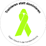 Trainieren statt dominieren – Logo Trainieren statt dominieren – Logo: Rundes Logo mit grünem Schleifenband in der Mitte. Umrandet von dem Schriftzug „Trainieren statt dominieren – Gegen Gewalt in der Hundeerziehung“.
